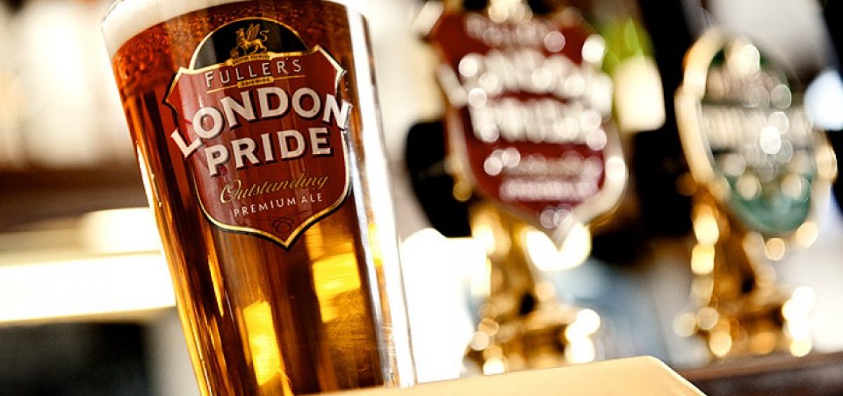 Fullers London Pride Ale in glass with tap handle in background