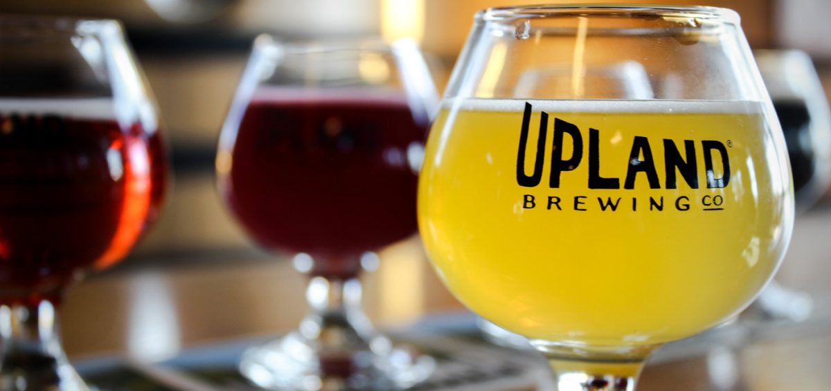 Upland Belgian style glass with logo and yellow colored beer inside