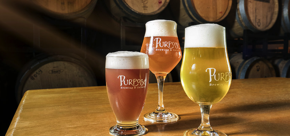 Purpose Brewing and Cellars three glasses with barrels in background