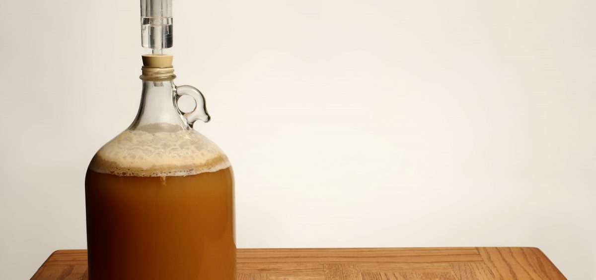 Fermenting Homebrew Beer in glass carboy on table
