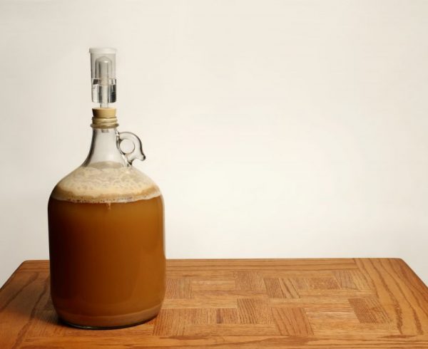 Fermenting Homebrew Beer in glass carboy on table