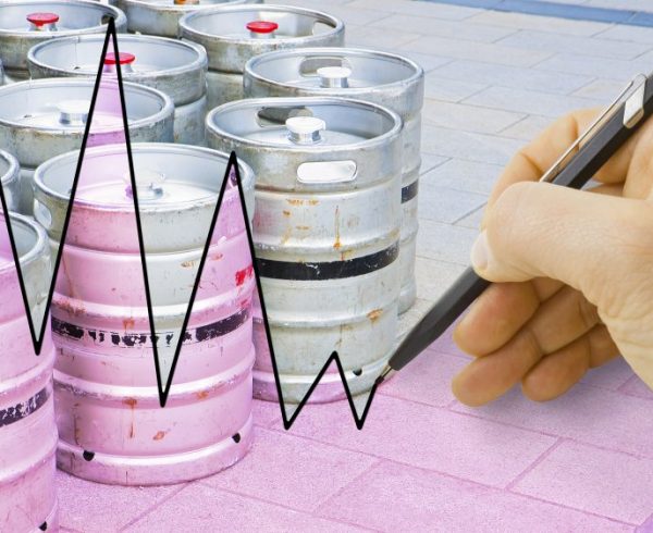 Hand drawing a graph about the trend of beer production with kegs of beer on background