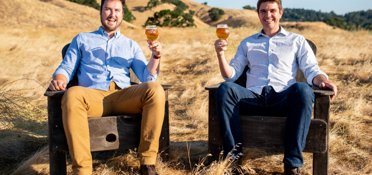 Side Gate Brewery Kevin and Paul sitting in a field with beers in hand