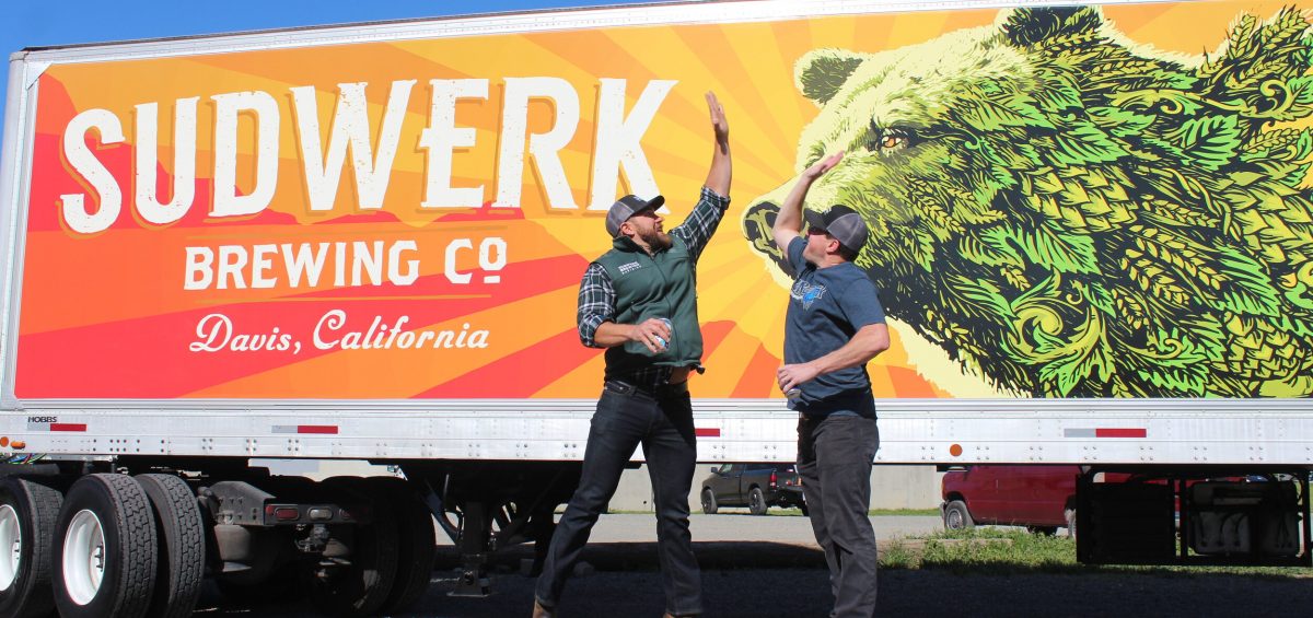 Sudwerk Brewing Company guys jumping to high five in front of truck