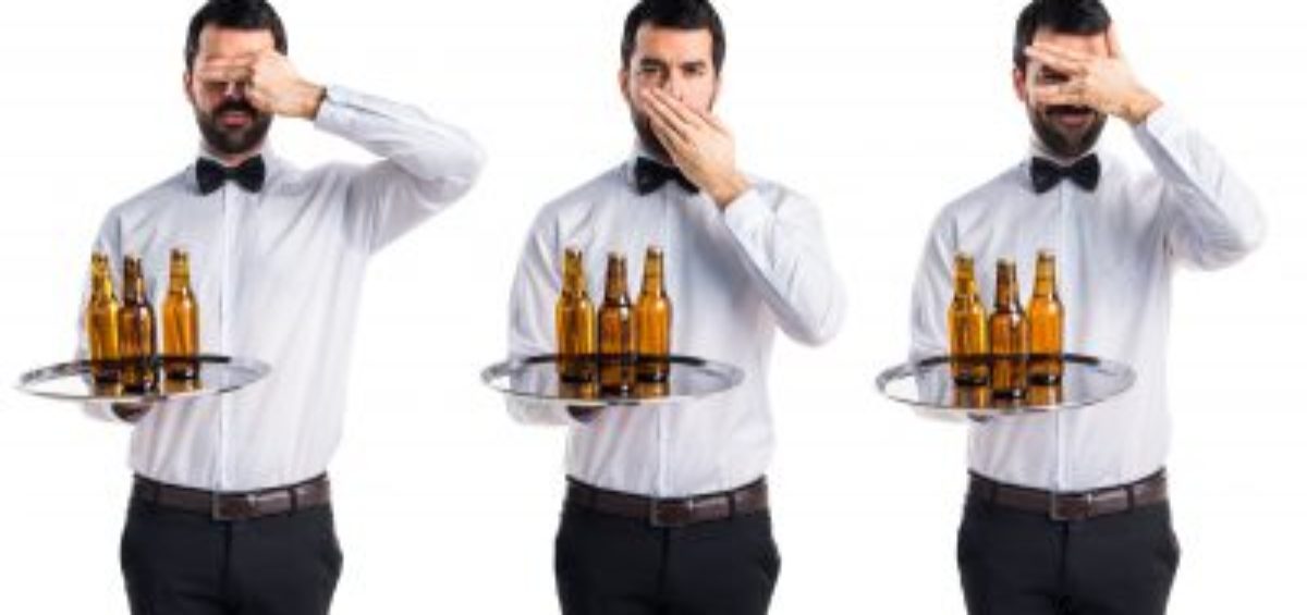 Waiter with beer bottles on the tray covering his mouth