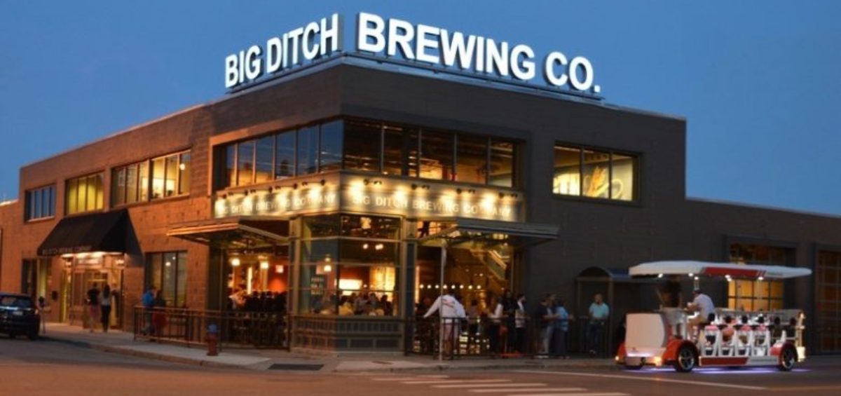 Big Ditch Brewing Co.building with sign on top and pedal cart out front