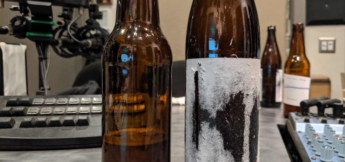 Two bottles of homebrewed beer sit in the studio of Dr. Homebrew
